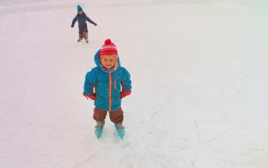 mutlu küçük kız ve oğlan kışın buz pateni