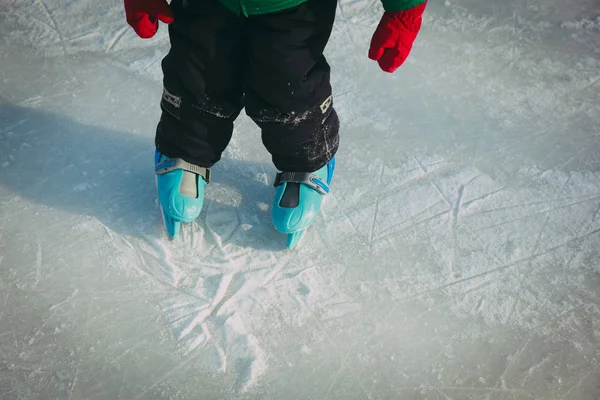 Ребенок учится кататься на коньках по льду зимой снега — стоковое фото
