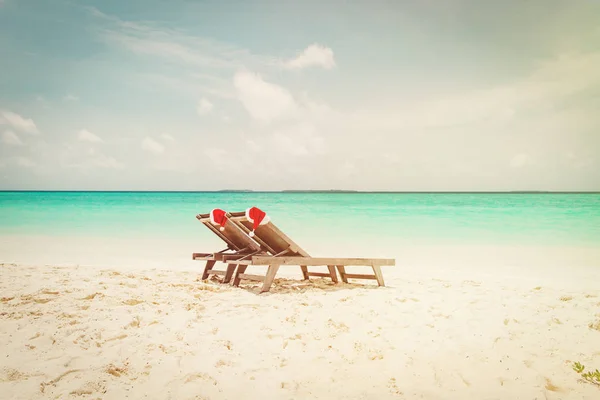 Natale sulle sdraio con i cappelli di Babbo Natale in mare — Foto Stock