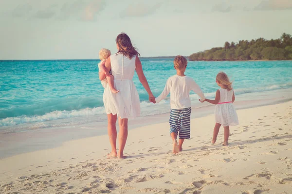Mutter mit drei Kindern spaziert am Strand — Stockfoto
