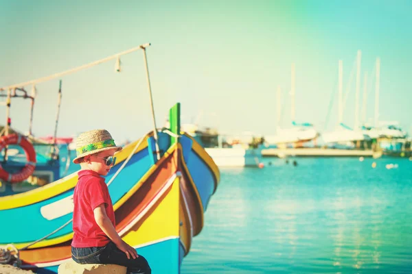 Маленький мальчик смотрит на традиционные лодки на Мальте — стоковое фото