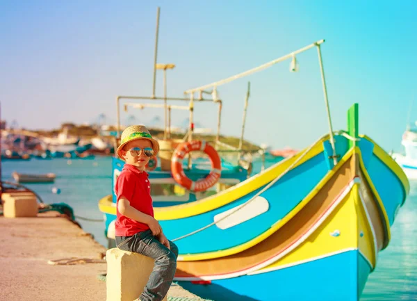Liten pojke tittar på traditionella båtar i malta — Stockfoto