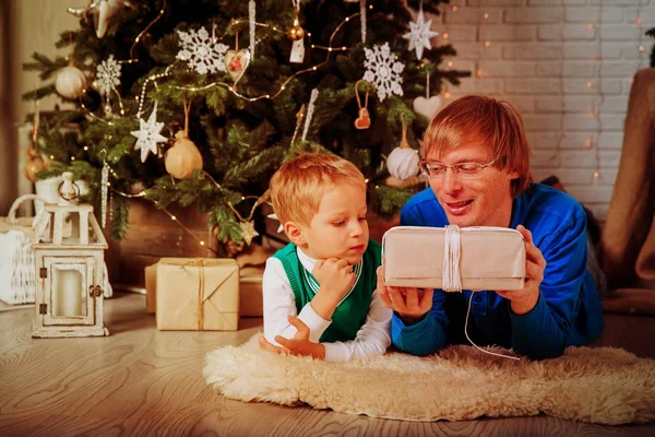 Πατέρας και γιος λαμβάνοντας χριστουγεννιάτικα δώρα στο σαλόνι — Φωτογραφία Αρχείου