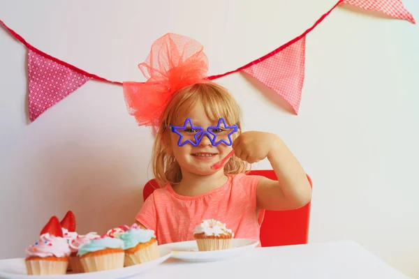 Menina feliz comendo doces na festa de aniversário — Fotografia de Stock