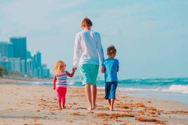 Baba ve iki çocuk Sahilde yürüyüş