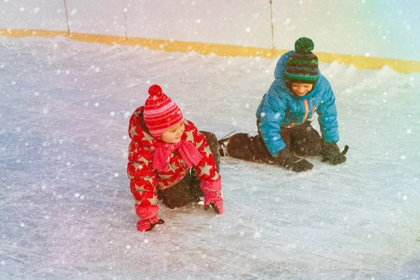 Mały chłopiec i dziewczynka nauki do skate, sport zima dla dzieci — Zdjęcie stockowe