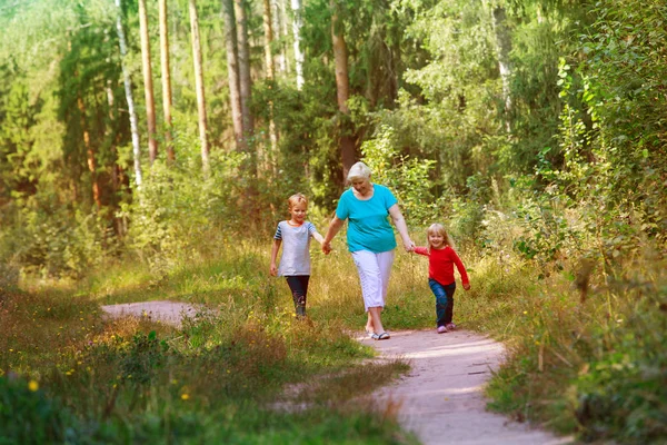 행복 한 할머니와 아이들 이 자연 속을 걷는 모습 — 스톡 사진