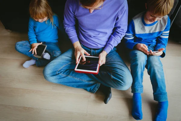 Padre con niños usando toch pad y teléfonos móviles —  Fotos de Stock