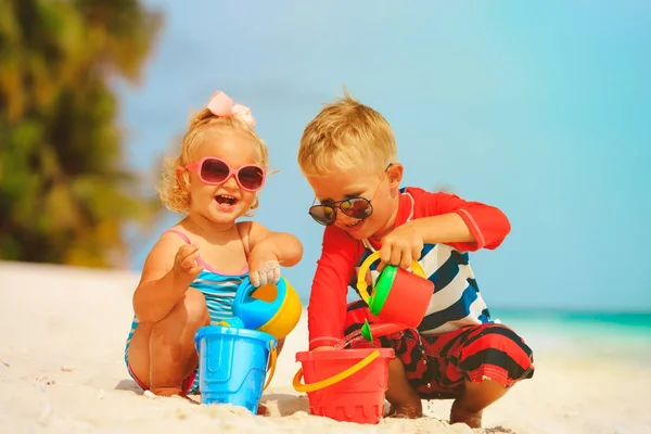 Мальчик и девочка играют с водой на пляже — стоковое фото
