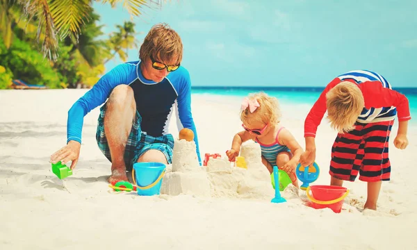 父亲带儿子和女儿在沙滩上玩 — 图库照片