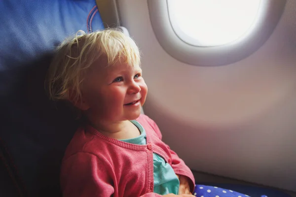 Pequena menina feliz viajar de avião — Fotografia de Stock