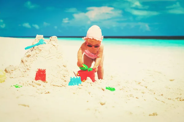 Carino bambina giocare con sabbia sulla spiaggia — Foto Stock