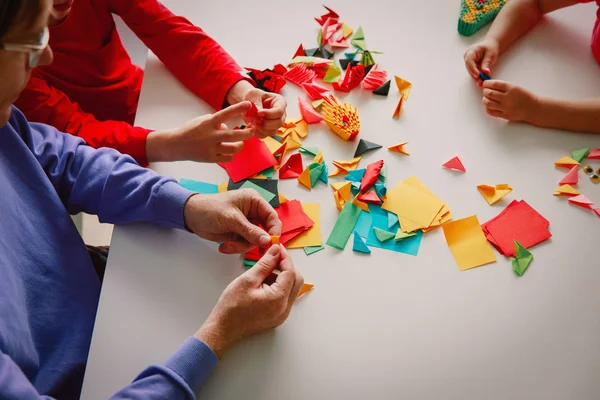 Läraren och barnen gör origami hantverk med papper — Stockfoto