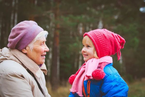 Happy grandmother and granddaughter talk in nature — Stock Photo, Image