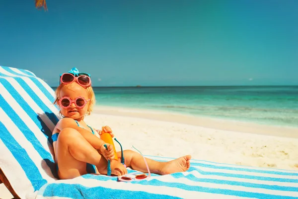 Schattig klein meisje proberen op zonnebril op strand — Stockfoto