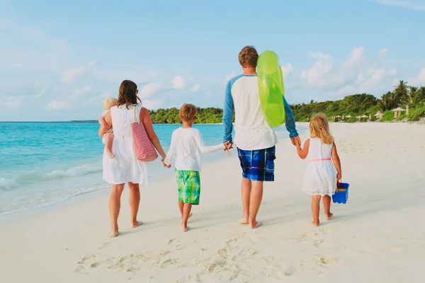 Üç çocuklu mutlu bir aile sahilde yürüyor. — Stok fotoğraf