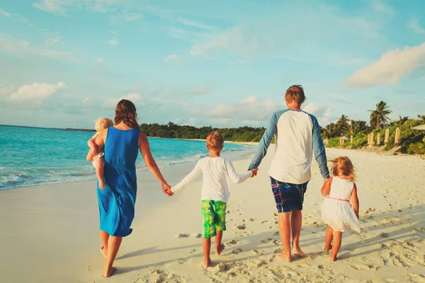 Üç çocuklu mutlu bir aile sahilde yürüyor. — Stok fotoğraf