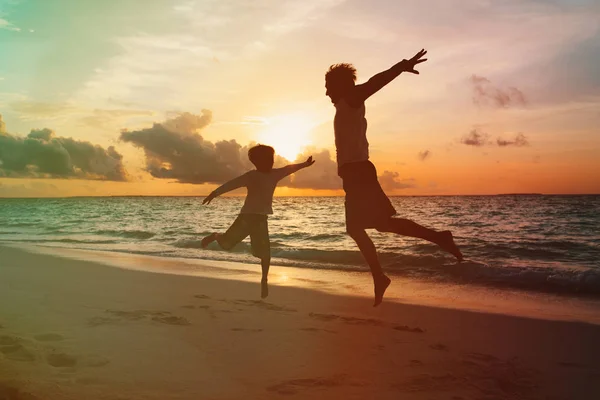 Padre e piccolo figlio godono di spiaggia al tramonto — Foto Stock