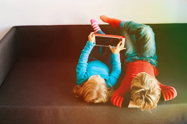 Kleine Jungen und Mädchen schauen zu Hause auf Touchpad — Stockfoto