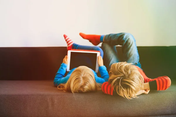 Kleine Jungen und Mädchen schauen zu Hause auf Touchpad — Stockfoto