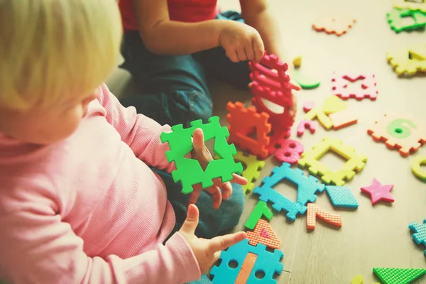 Niños jugando con rompecabezas, aprendiendo formas y números —  Fotos de Stock