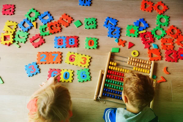 Sayıları hesaplamak küçük erkek ve kız çocuk öğrenmek — Stok fotoğraf