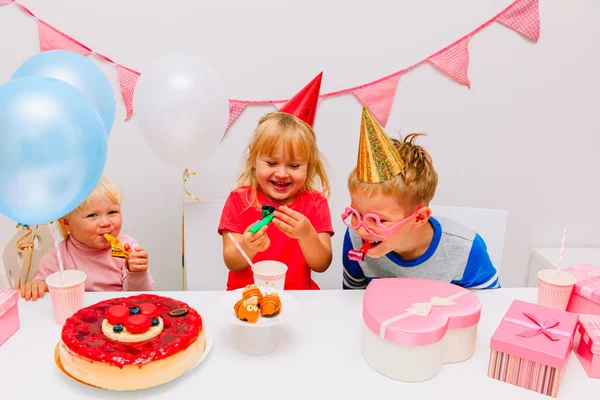 Bambini felici con regali e dolci giocano alla festa di compleanno — Foto Stock