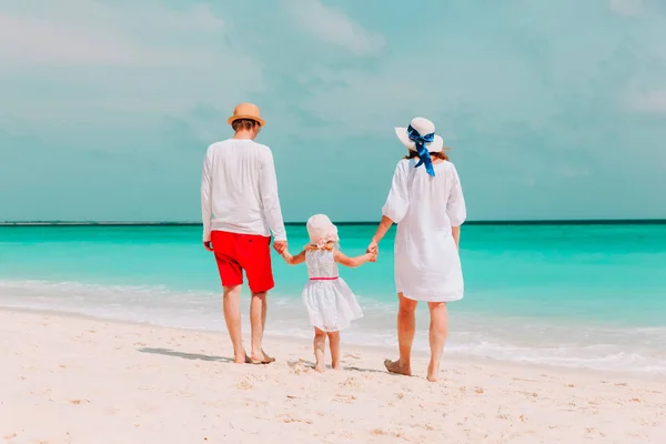 Jonge liefdevolle familie met kleine dochter wandelen op strand — Stockfoto