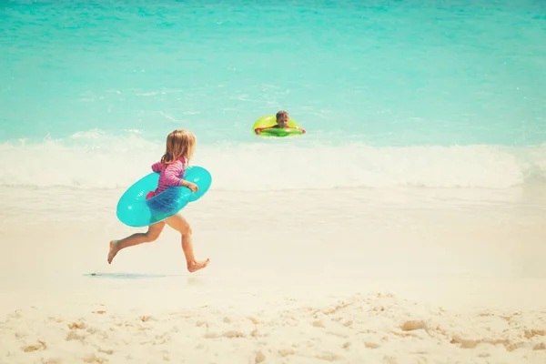 Petite fille et garçon jouer nager sur la plage — Photo