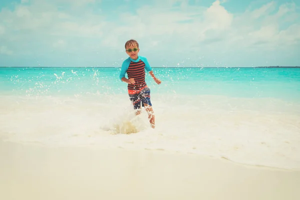 Felice bambino correre giocare con le onde sulla spiaggia — Foto Stock