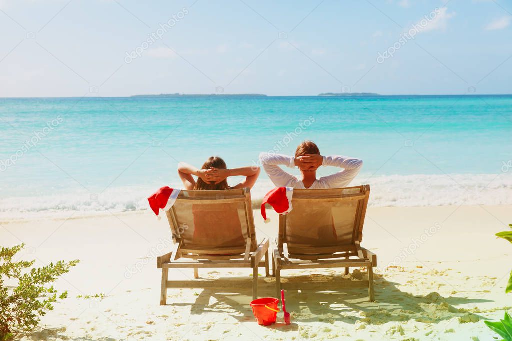 Christmas on beach -chair lounges and happy couple at sea