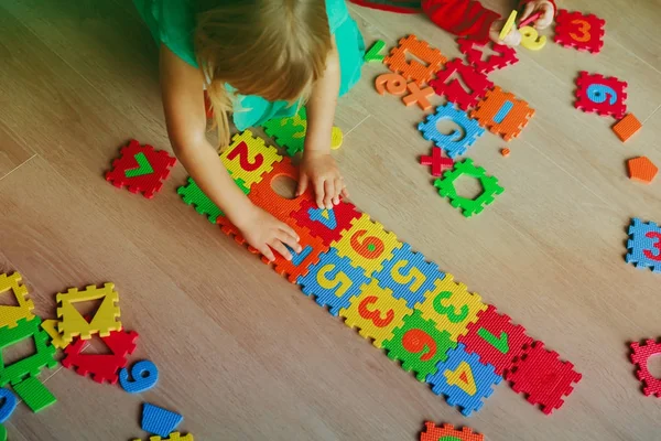 Crianças brincando com quebra-cabeça, aprendendo números e formas — Fotografia de Stock