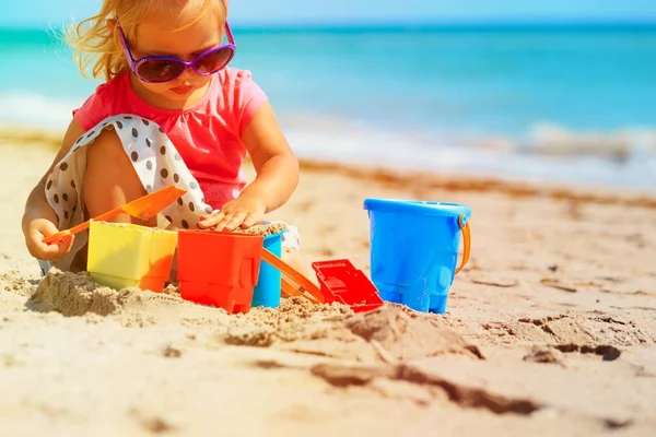 Carino bambina giocare con sabbia sulla spiaggia — Foto Stock