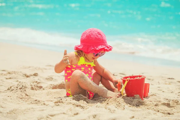 Cute little girl play with sand on beach — Stock Photo, Image