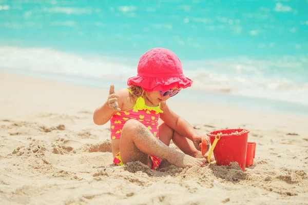 Schattig klein meisje spelen met zand op het strand — Stockfoto