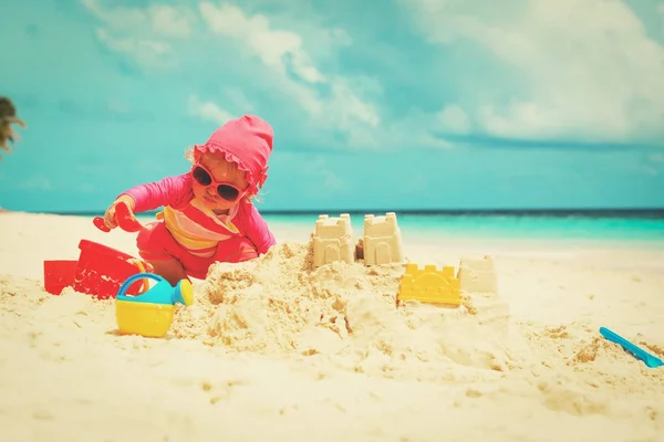 Cute little girl play with sand on beach — Stock Photo, Image