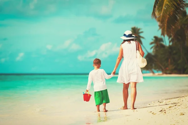 Moeder en zoontje lopen op tropisch strand — Stockfoto