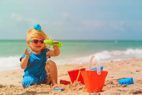 Bonito menina jogar com areia na praia — Fotografia de Stock