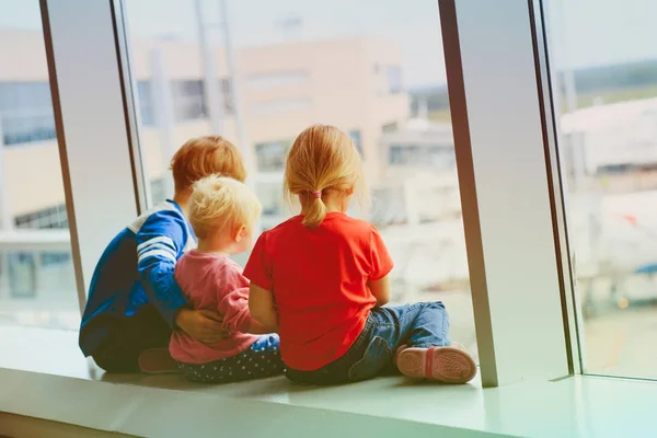 Niños esperando avión en aeropuerto — Foto de Stock