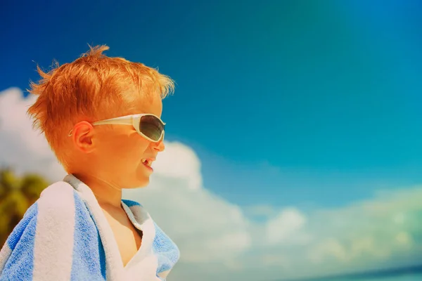 Happy little boy wrapped in towel on beach — Stock Photo, Image