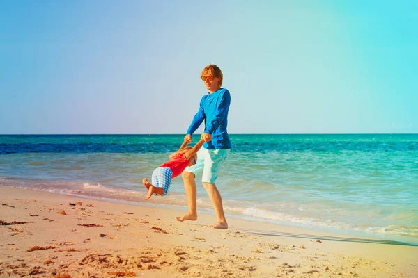 Отец и маленькая дочь играют на пляже — стоковое фото