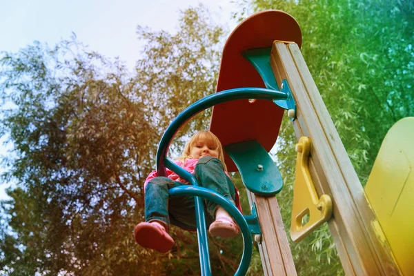 Mignonne petite fille jouer sur aire de jeux en plein air — Photo
