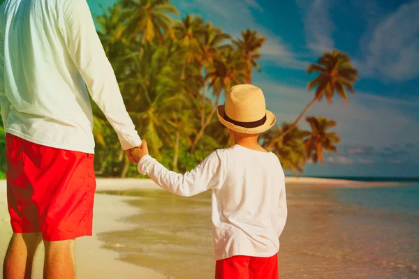 Padre e hijo tomados de la mano en la playa —  Fotos de Stock