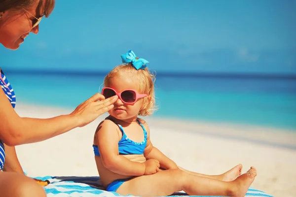 Mother applying sunblock cream on daughter shoulder — Stock Photo, Image