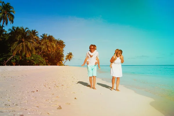 两个小孩的家庭在热带海滩上行走 — 图库照片