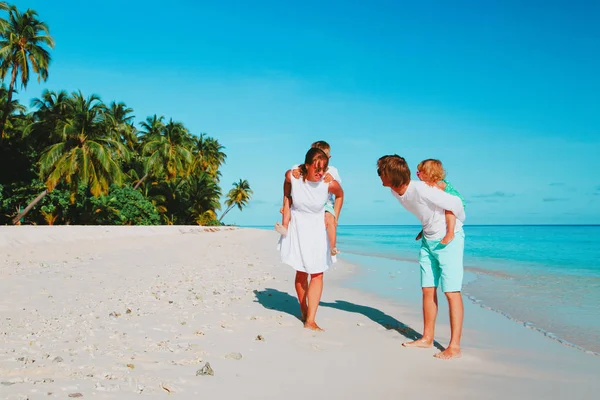 两个小孩的家庭在热带海滩上行走 — 图库照片