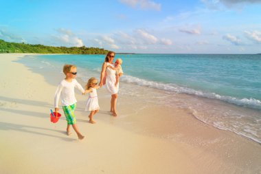 Anne ile küçük oğlu ve kızı yürüyüş sahilde