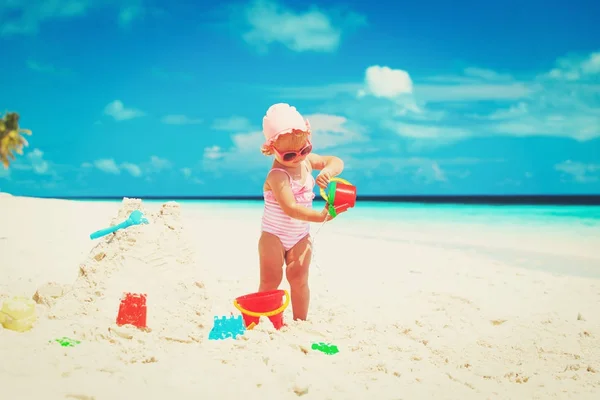 Schattig klein meisje spelen met zand op het strand — Stockfoto