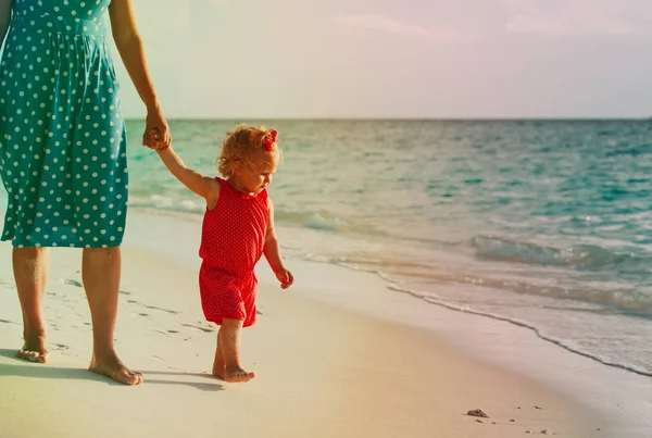 mother and daughter walking on beach