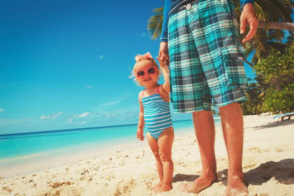 Vader en dochtertje hand in hand op strand — Stockfoto